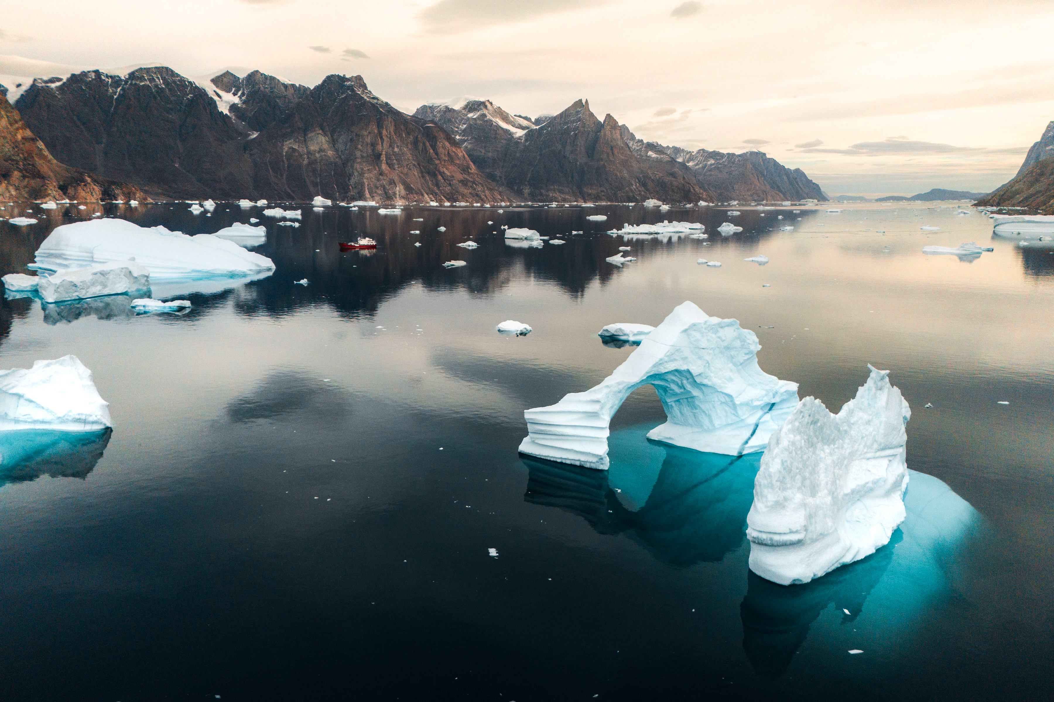 Icebergs in ofjord greenland with mountains in background